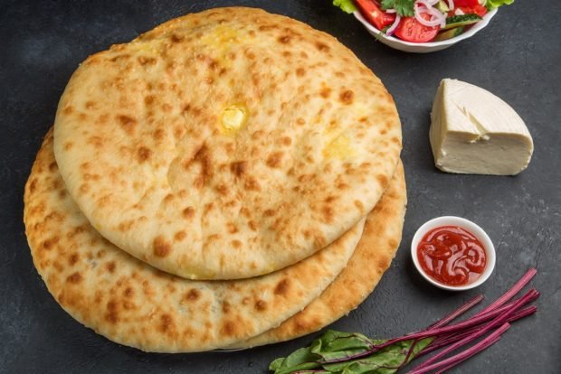 Khachapuri with tops and cheese in a frying pan 