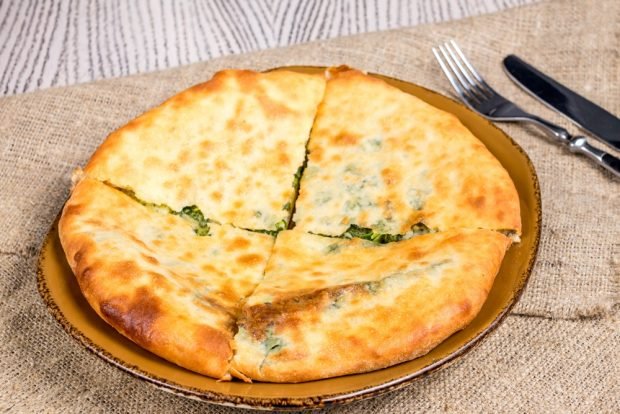 Khachapuri with chicken and spinach in a frying pan 