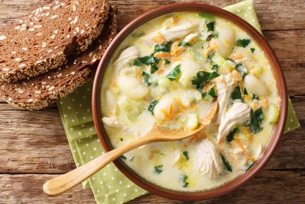 Chicken soup with spinach, beans and melted cheese
